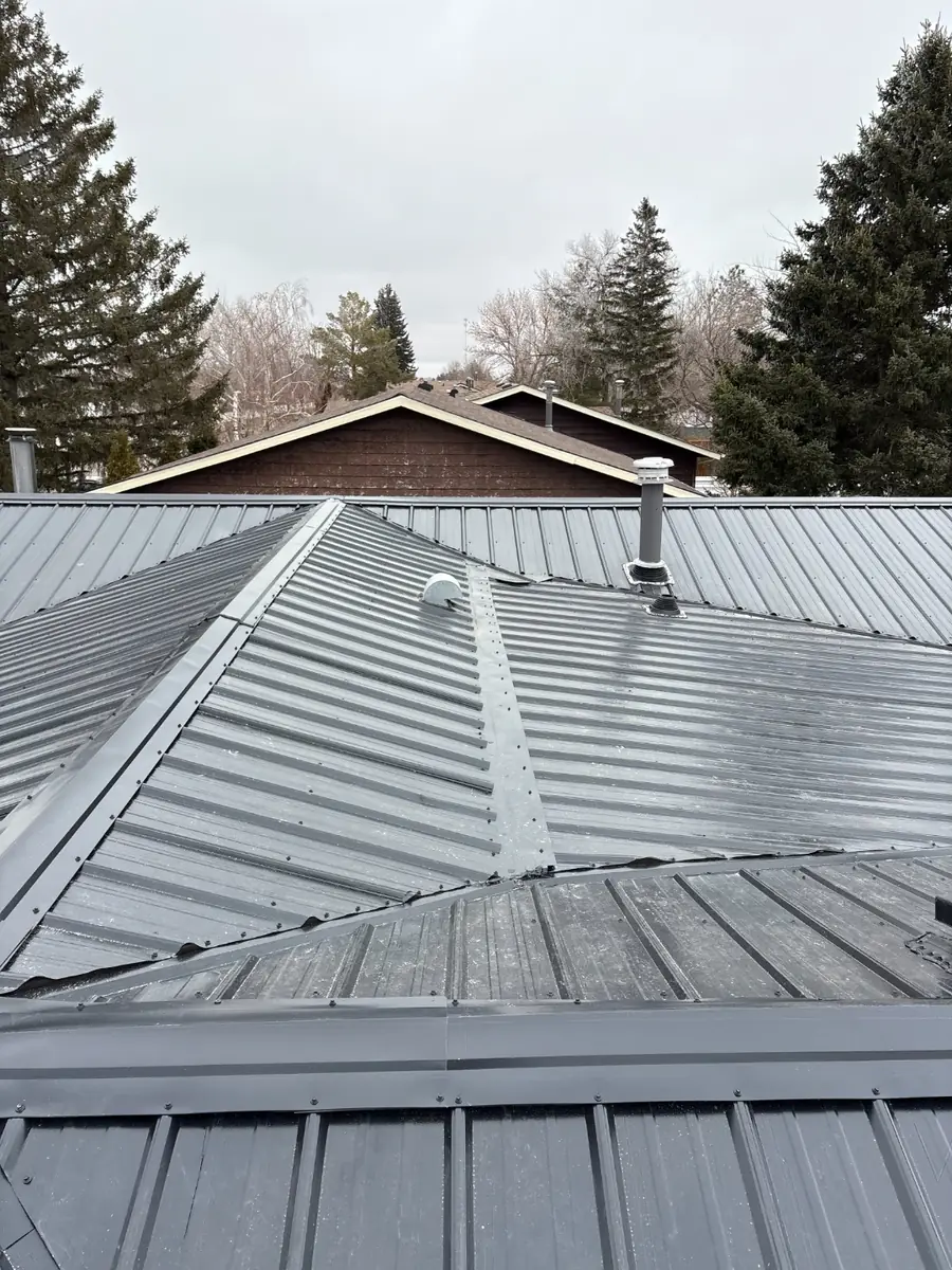 Metal roof hip and ridge detail with sealed plumbing stack flashing