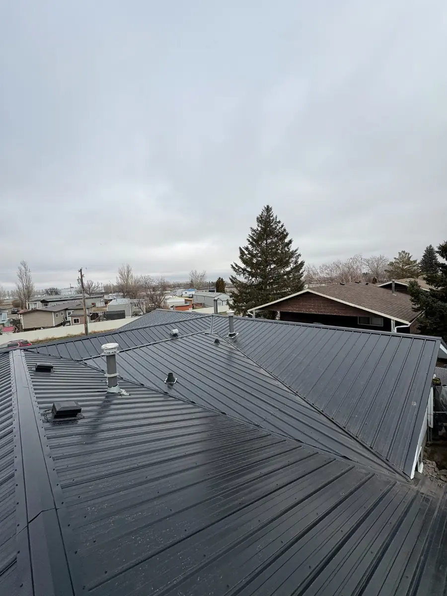 Finished metal roof with vents and ridge caps on a bungalow in Alberta